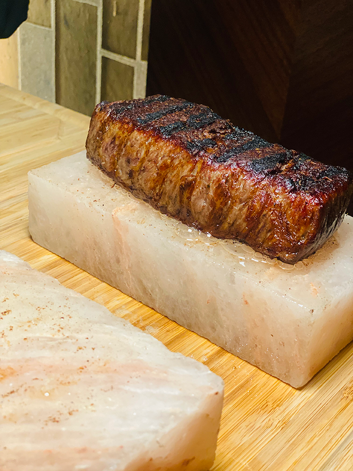 slab of meat atop a carved salt platter.