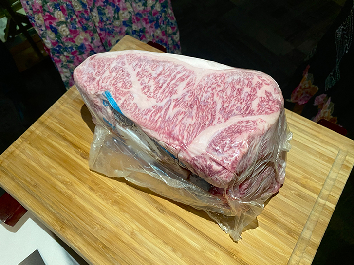 a chunk of wagyu wrapped in plastic, the marbled fat is prominent