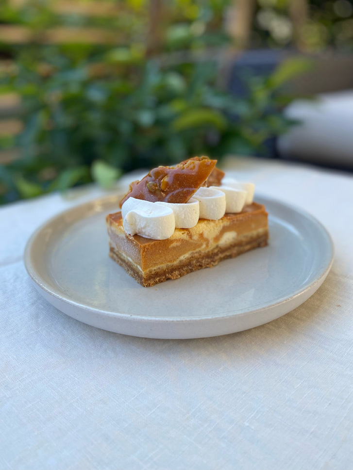 Dessert bar with tiny marshmallows and caramel on top on white plate