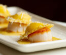 Three pieces of scallop with ravioli on top.