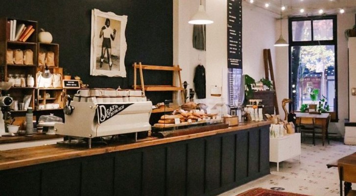 The counter area of the cafe, with a white coffee machine and pastries