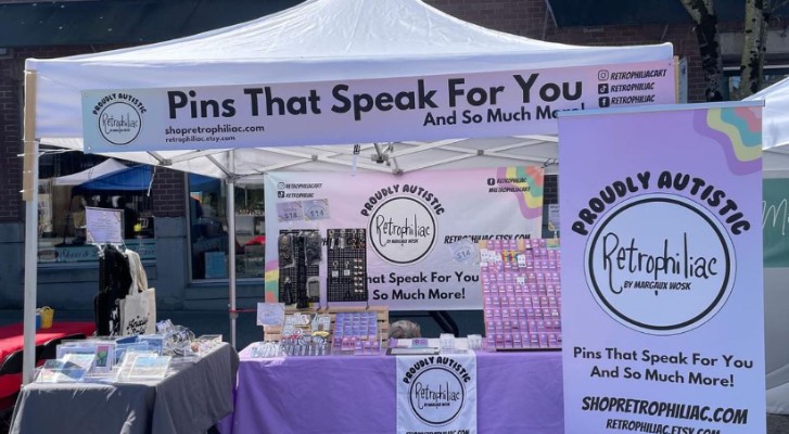 A booth with stickers and pins being sold 