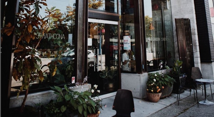 A store front with large windows and flowers around