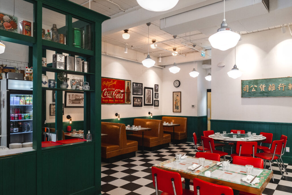 A restaurant interior with checkerboard floors and bright red chairs. 