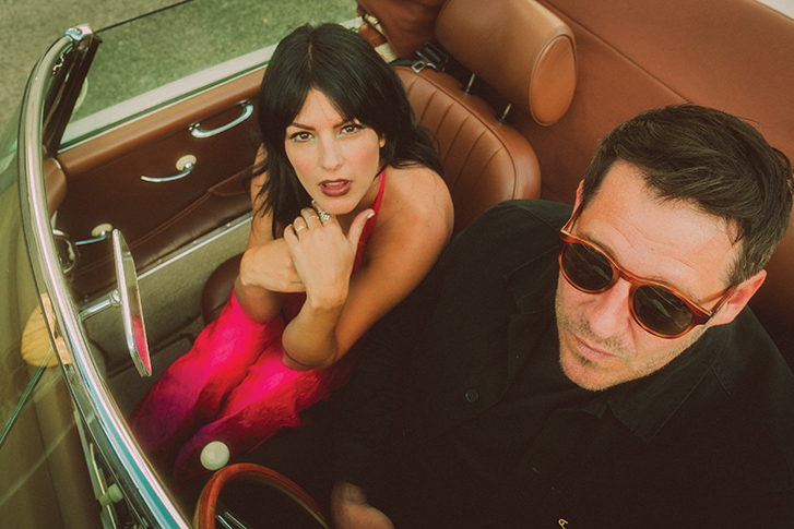 the band Dear Rouge sits in a vintage car looking at the camera