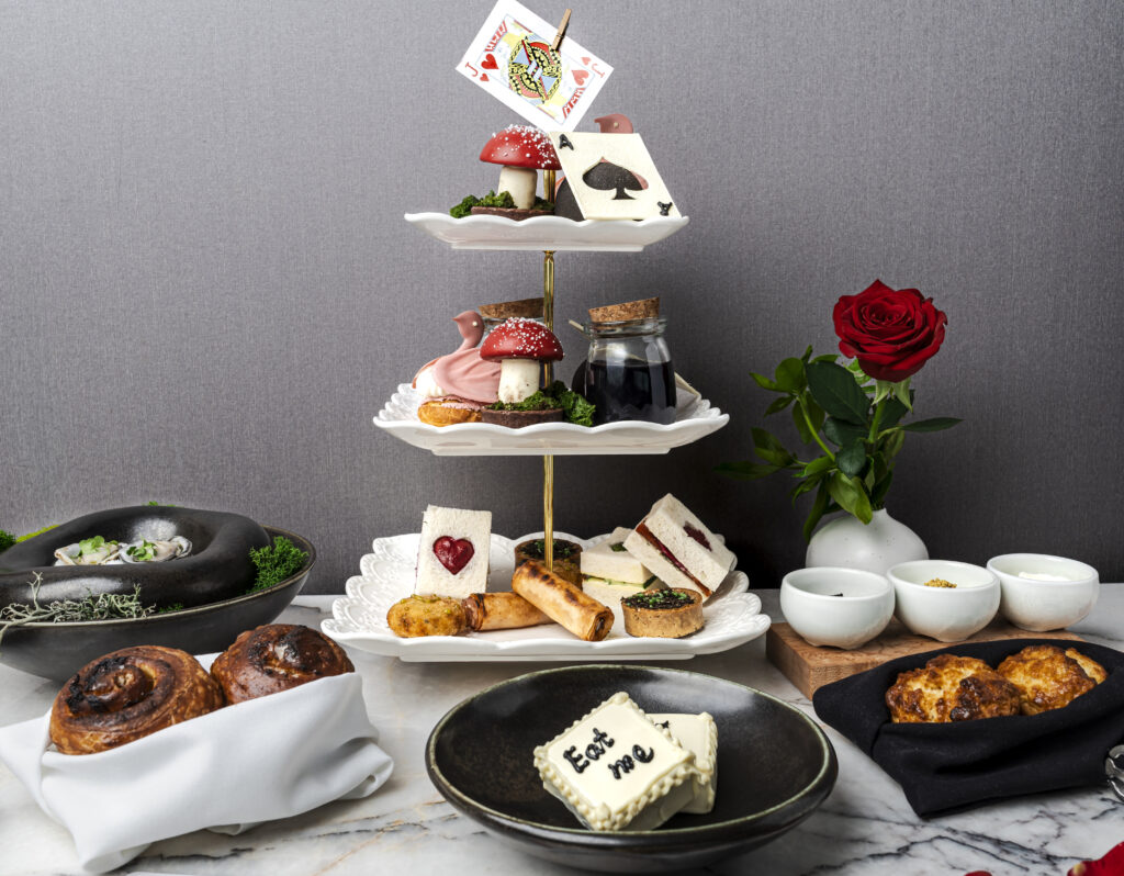 A three-tiered afternoon tea setting of sweet and savoury snacks.