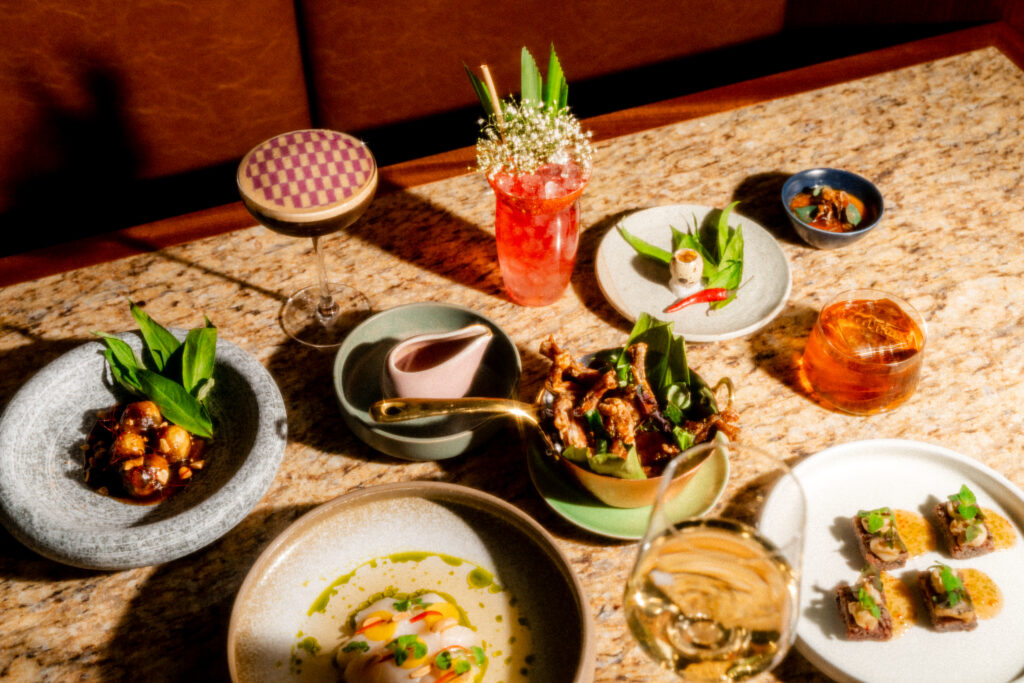 A spread of Vietnamese food, including cocktails, spring rolls, and other artful dishes.