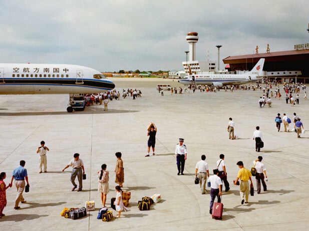 People walking to and from passenger planes on an airport tarmac.