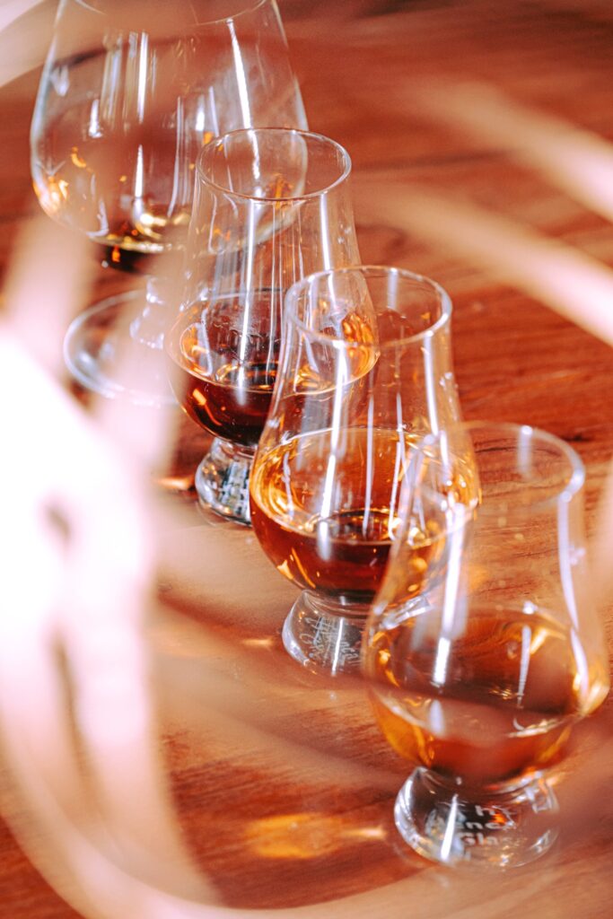 Whiskey-tasting glassware lines a table.