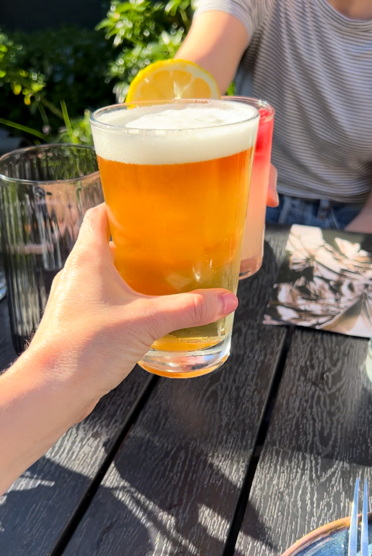 hands holding a beer and a cocktail, cheersing