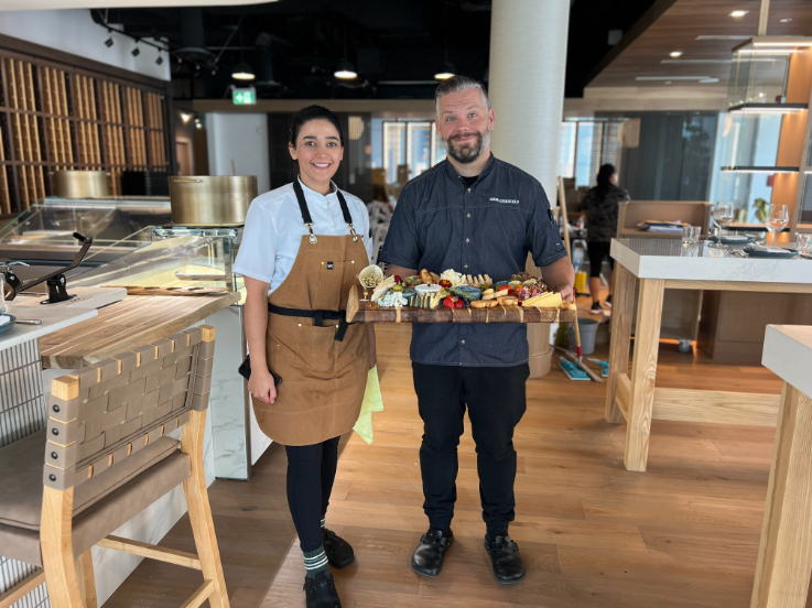 chefs hold a platter of meat and cheese