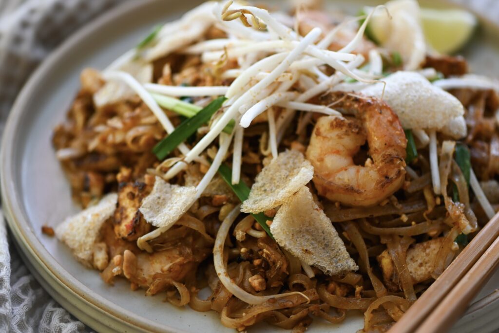 A plate of prawn Pad Thai with a scattering of bean sprout.