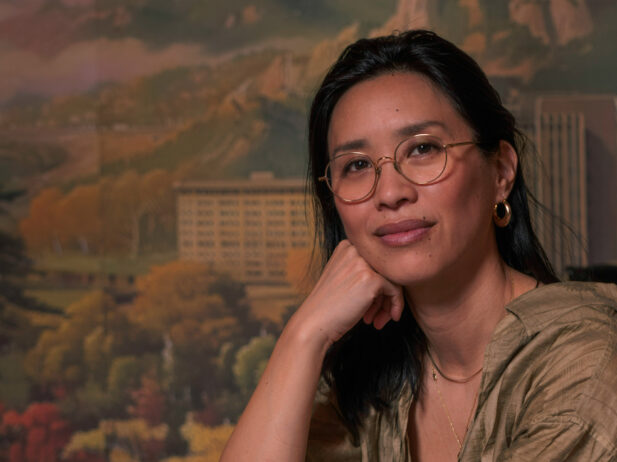 tannis ling sits at table in front of mural