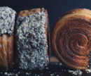 Three round croissants, black background.