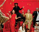 people in party clothes throwing confetti in a red room