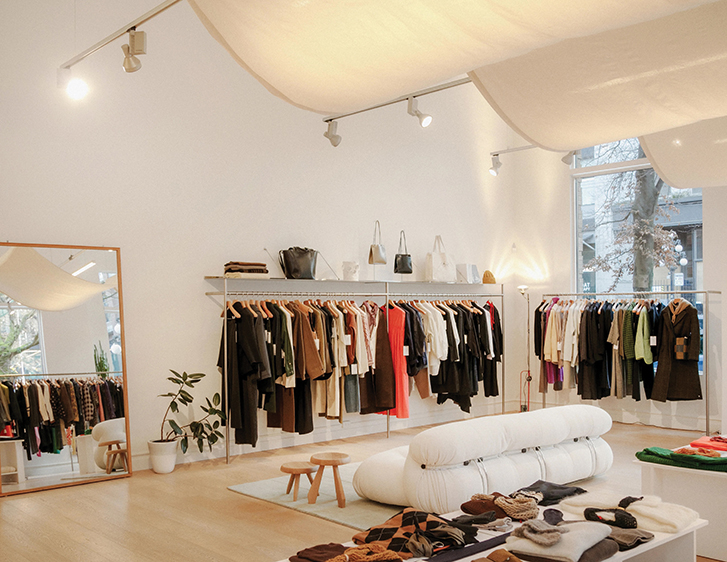 racks of clothing hanging in a bright and airy room